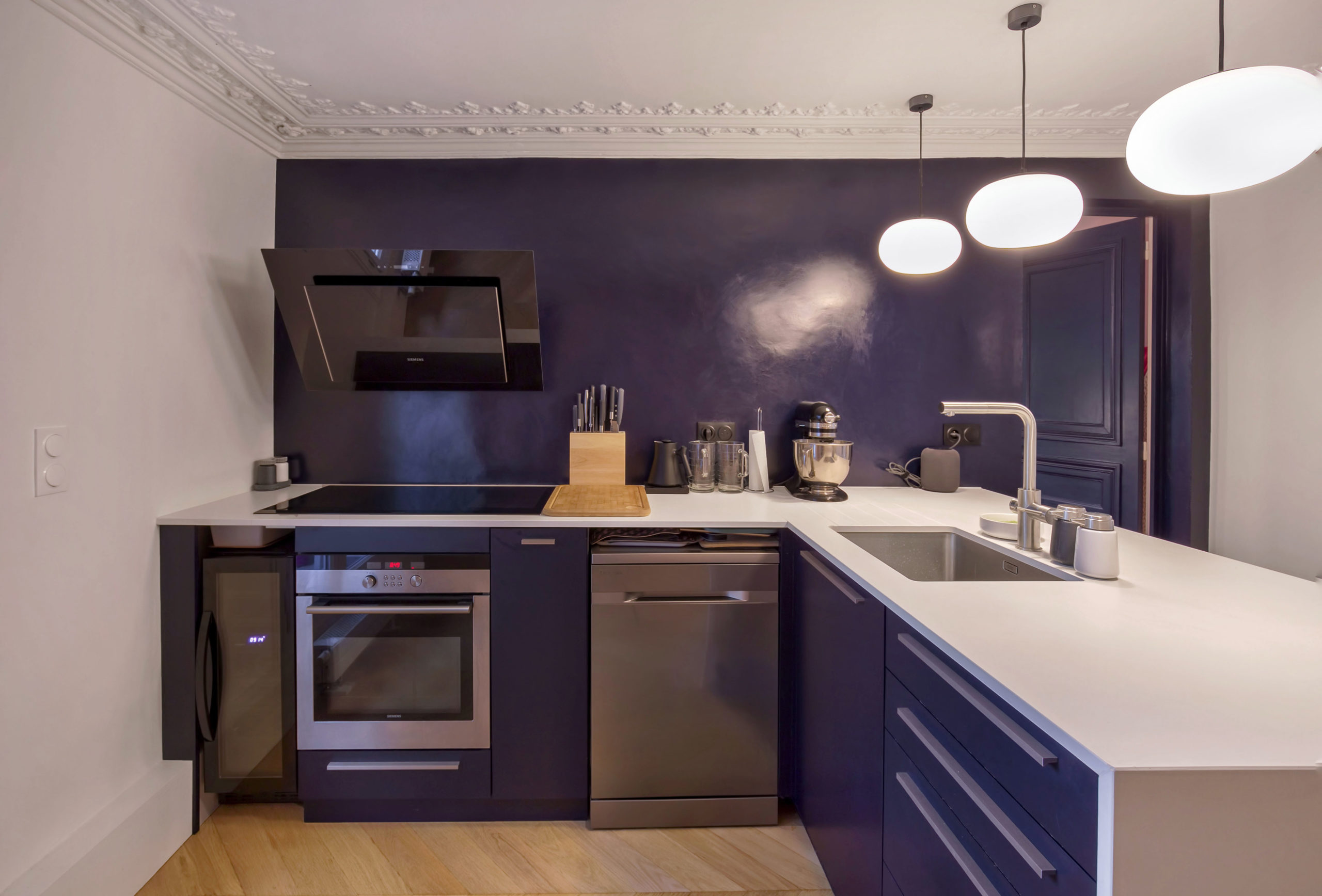 The kitchen with its deep blue waxed concrete wall